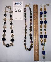 All three necklaces laid out side by side beneath a lot tag