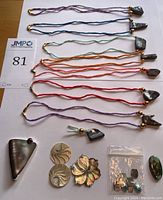 Overall view of seven silk cord opal necklaces, mother-of-pearl shells, statement pendant and bag of cabochons