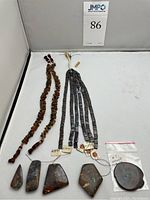 Five freeform opal slabs at bottom with two rondelle bead strands left and five square tile strands right