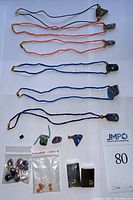 Overview of six opal necklaces on colored cords, loose opal fragments, fire opal beads and mother-of-pearl pendants