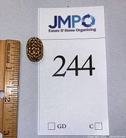 Gold and ruby bead pendant next to ruler showing approx 3/4 inch length