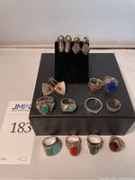 Overview of nine rings and three pairs of earrings on display