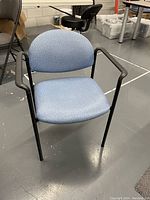 Single light blue upholstered chair showing padded seat and back with black frame