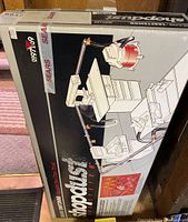 Photo of original cardboard box containing Craftsman Shopdust M System tubing and connectors for dust collection system, showing product branding and illustration of system connected to woodworking tools.