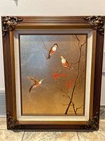 Frontal view of framed gold leaf hummingbird painting