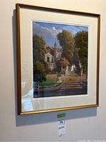 Framed artwork showing detailed estate and garden scene with human figures and boat on water. Gold composite frame with white mat.