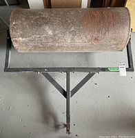 Top-down view of steel drum roller on frame