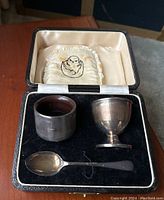 Complete set of three sterling silver child dish items displayed in the original black case with a silk interior and a small embroidered pouch for the spoon.