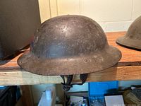 Exterior side view showing dome and brim with surface rust and patina