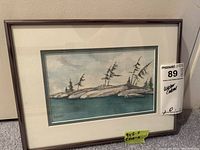 Framed watercolour landscape painting with a view of rocky shoreline, pine trees, and water, signed by S. Gunn with seller's lot number sticker on frame.