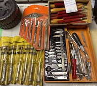 Overview photo showing nut driver set, drill bits set, carving gouges and chisels, and assorted Xacto blades and handles in trays and packaging.