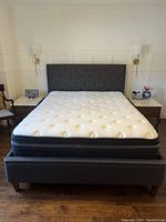 Front view of entire upholstered bed frame and mattress
