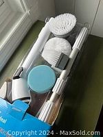 Top view of the power scrubber with several detachable brush attachments.