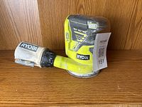 Photo showing the side profile of the Ryobi One Plus circular sander with dust bag attached.