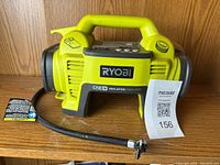 Front view of Ryobi One+ inflator/deflator with control panel, handle, and hose attached, showing condition and markings.