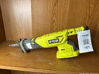 Side view of the Ryobi One Plus Sawzall cordless reciprocating saw showing the Ryobi logo and blade clamp.