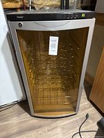 Front view of Haier wine fridge showing glass door, digital control panel, and temperature display at 67 degrees Fahrenheit
