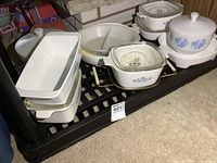 Front view showing multiple CorningWare and FireKing dishes on shelf