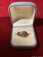 Front view of ring face showing 'DAD' inscription with pavé diamond center.