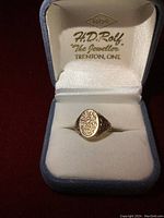 Ring displayed upright in a jeweler's box interior showing overall appearance and box branding