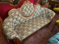 Full frontal view of the Regency style settee showing floral brocade upholstery and the carved wooden frame with grape cluster motif.
