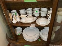 Full view of top and middle shelves showing cups, mugs, creamer, sugar bowl, butter dish, salt and pepper shakers