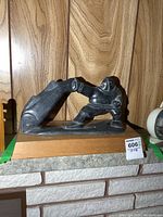 Full front view of sculpture on wood base