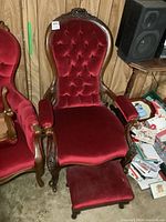 Front view of chair with footstool in red velvet and carved wood