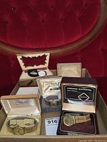 Group shot of five men’s wrist watches in original boxes on red upholstery background