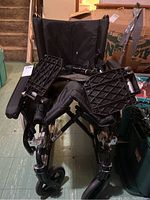 Front view showing seating area with footrests lowered and front caster wheels.