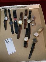 Top-down view of all nine watches laid in cardboard box