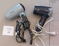 Photo showing the two travel hair dryers side by side, one silver George Brown and one black Power Style Ionity model, with cords visible.