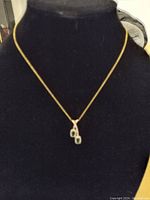 Created emeralds necklace displayed on a black bust.