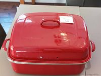 Large red enamel basting pan with matching lid in place shown from above.