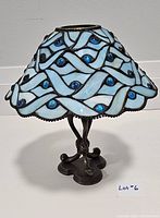 Full view of the assembled Partylite Tiffany-style blue and white stained glass table lamp with blue glass bead accents and bronze metal base with ornate three-leg design.