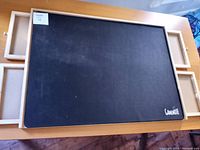 Top view of the puzzle board showing the black playing surface with the brand name 'GameNote' and four wooden drawers extended from the frame.