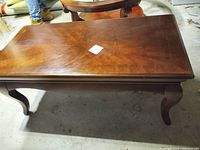 Full view of rectangular wood coffee table showing scratches and wear on the top surface.