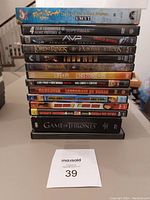Stack of various DVD cases showing title spines and front labels of movies and TV series included in the lot.