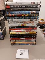 Stack of various DVD movies in their cases clearly visible with many recognizable titles.