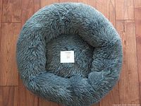 Top-down view of the grey fluffy calming pet bed, showing its round shape and plush interior.