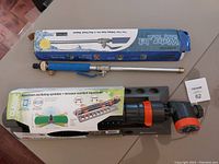 Photo of oscillating sprinkler in original box along with pressure hose adaptor wand.