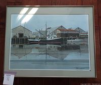 Framed waterfront print showing boats and dock buildings reflecting in the water