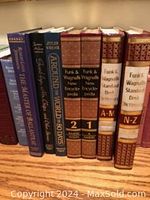 Photo showing encyclopedia volumes and dictionaries with brown binding and gold lettering