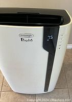 Front view of white DeLonghi Pinguino portable air conditioner with digital display showing temperature 75 and control buttons on side.