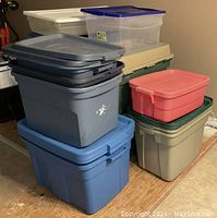 Stack of Rubbermaid storage bins in different colors and sizes, mostly with lids, condition excellent.