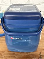 Front and side view of the blue Breg Polar Care Cube ice cooler showing logo and unit shape.