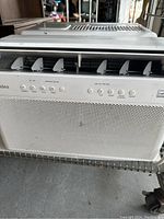 Close-up front view of Midea air conditioner control panel showing vents and operational buttons.