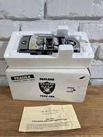 Oakland Raiders team car in original foam packaging atop its box with instruction sheet.