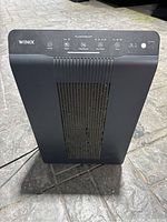 Front view of the black Winix PlasmaWave air purifier fan showing control buttons and vented grille.