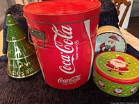 Front view of all four tins showing Coca-Cola branding and Christmas designs